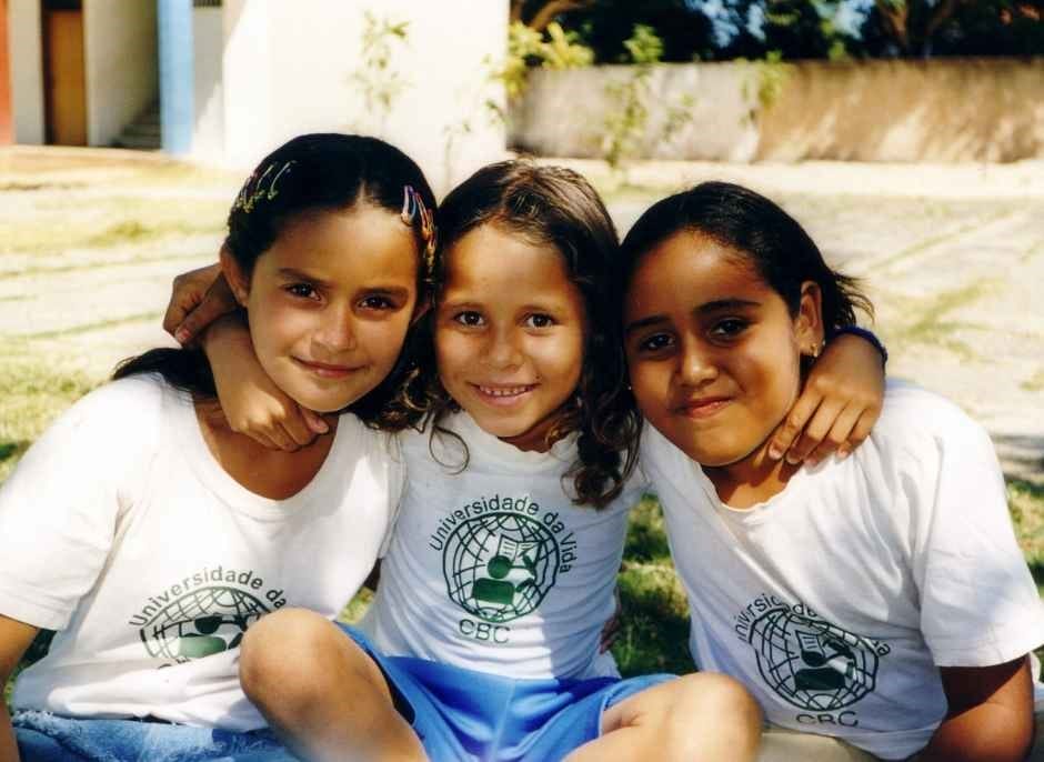 three girls hugging in the courtyard at cbc