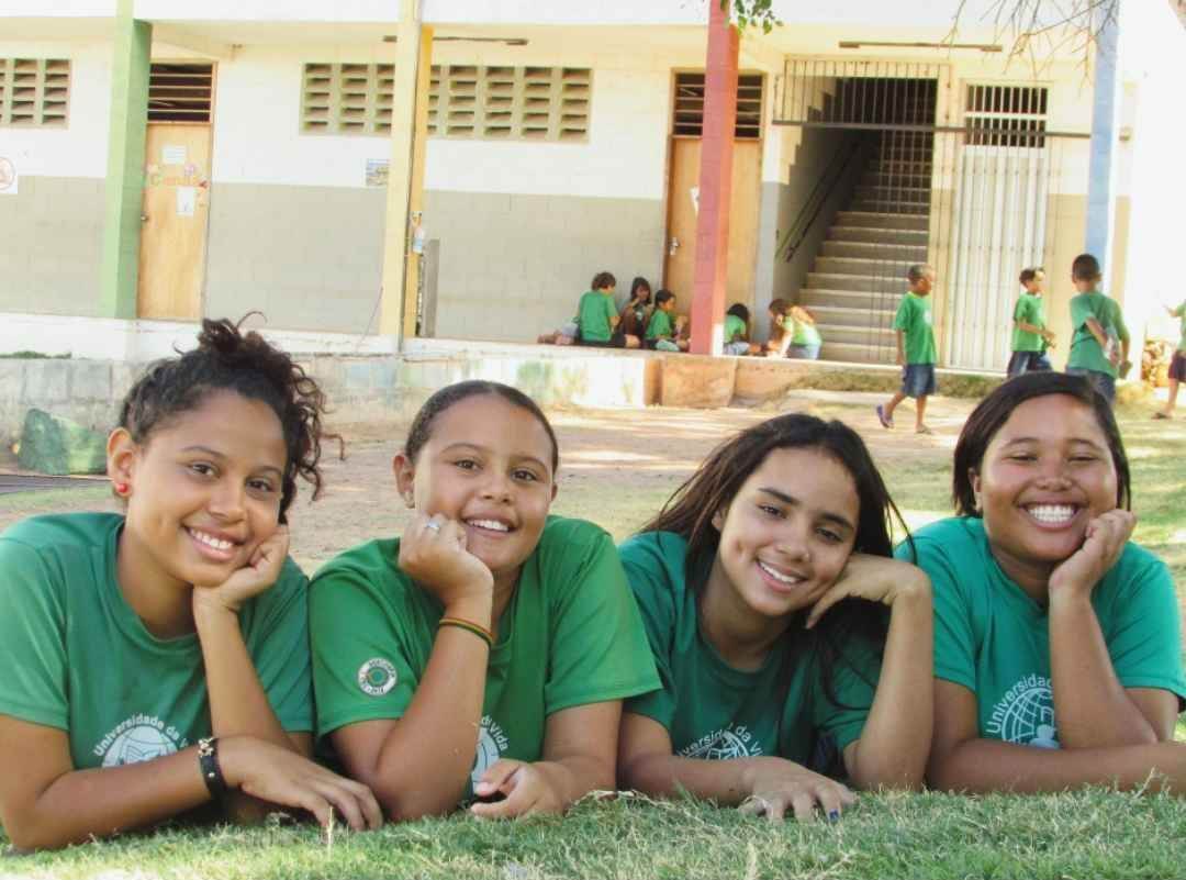 four girls in field in front of classroom building at cbc