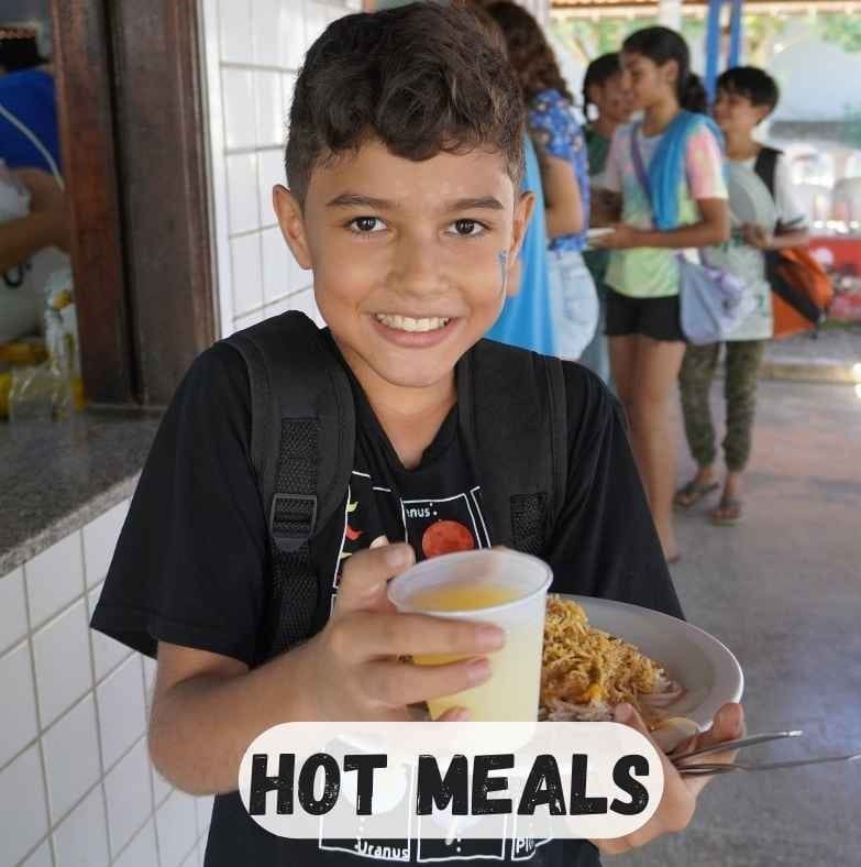 boy standing in front of kitchen with hot pasta and juice