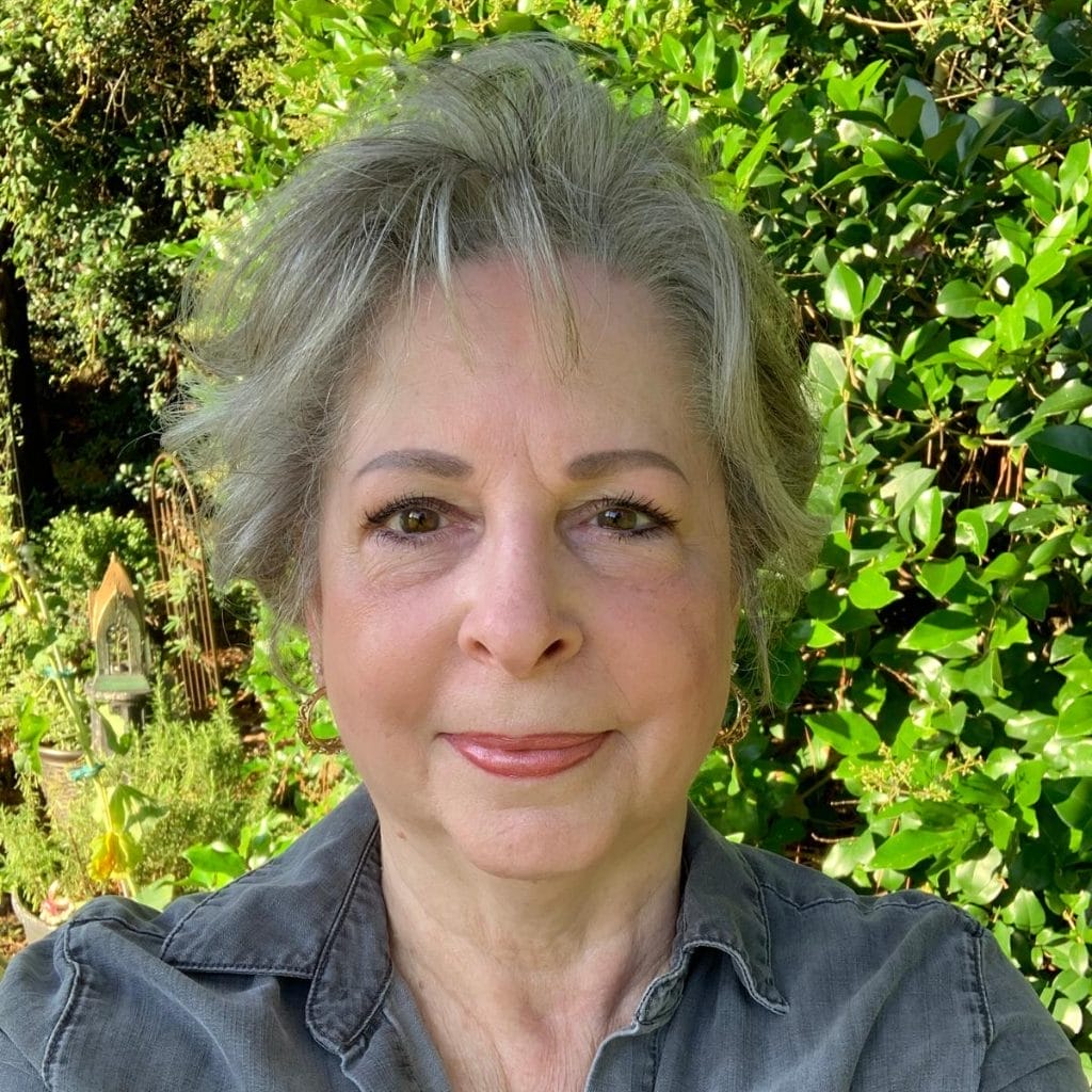 Teresa in front of bush and garden